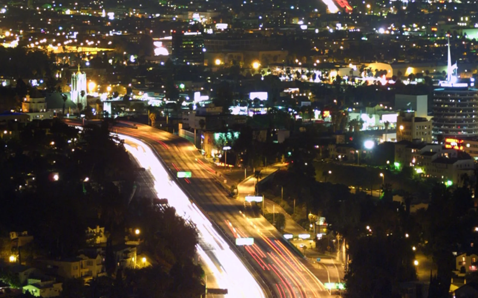 The Los Angeles freeway system at night with lights and city glow, showing the urban density of Southeast LA County